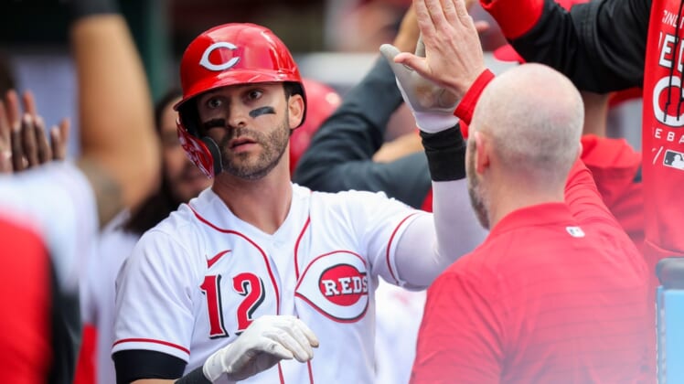 Apr 12, 2022; Cincinnati, Ohio, USA; Cincinnati Reds right fielder Tyler Naquin (12) high fives teammates after hitting a home run against the Cleveland Guardians in the sixth inning at Great American Ball Park. Mandatory Credit: Katie Stratman-USA TODAY Sports