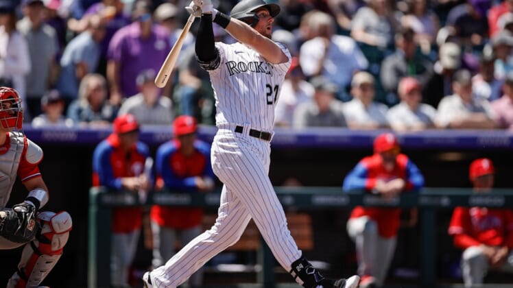 Apr 20, 2022; Denver, Colorado, USA; Colorado Rockies third baseman Ryan McMahon (24) watches his ball on an RBI double in the first inning against the Philadelphia Phillies at Coors Field. Mandatory Credit: Isaiah J. Downing-USA TODAY Sports