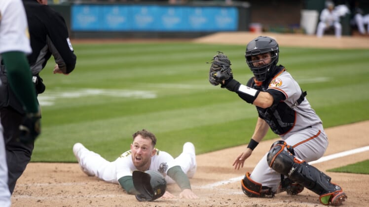 Apr 20, 2022; Oakland, California, USA; Oakland Athletics right fielder Billy McKinney looks to home plate umpire Greg Gibson for the call after being tagged out by Baltimore Orioles catcher Anthony Bemboom (37) during the second inning at RingCentral Coliseum. Mandatory Credit: D. Ross Cameron-USA TODAY Sports