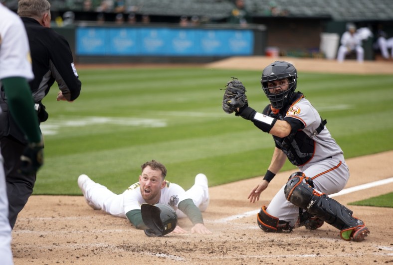 Apr 20, 2022; Oakland, California, USA; Oakland Athletics right fielder Billy McKinney looks to home plate umpire Greg Gibson for the call after being tagged out by Baltimore Orioles catcher Anthony Bemboom (37) during the second inning at RingCentral Coliseum. Mandatory Credit: D. Ross Cameron-USA TODAY Sports