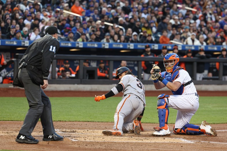 Apr 20, 2022; New York City, New York, USA; New York Mets catcher James McCann (33) tags out San Francisco Giants shortstop Brandon Crawford (35) at home plate during the first inning at Citi Field. Mandatory Credit: Vincent Carchietta-USA TODAY Sports