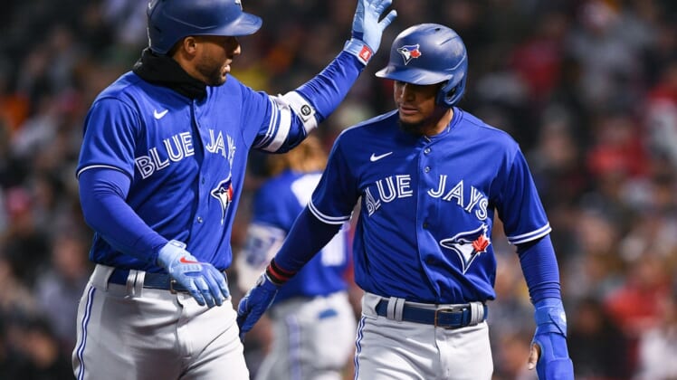 Apr 20, 2022; Boston, Massachusetts, USA; Toronto Blue Jays center fielder George Springer (4) celebrates with second baseman Santiago Espinal (5). Espinal scored on a sacrifice fly hit by Springer during the second inning at Fenway Park. Mandatory Credit: Brian Fluharty-USA TODAY Sports