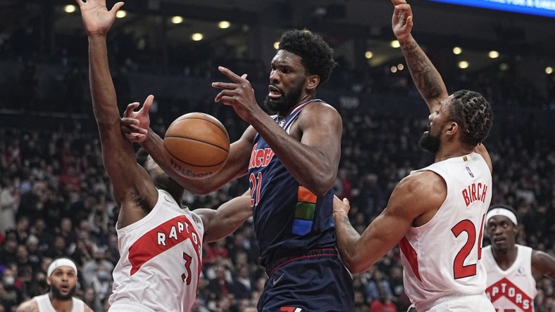 Apr 20, 2022; Toronto, Ontario, CAN; Toronto Raptors forward OG Anunoby (3) and center Khem Birch (24) knock the ball away from Philadelphia 76ers center Joel Embiid (21) during the first half of game three of the first round for the 2022 NBA playoffs at Scotiabank Arena. Mandatory Credit: John E. Sokolowski-USA TODAY Sports