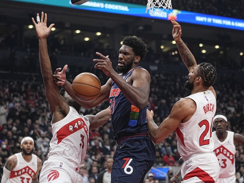 Apr 20, 2022; Toronto, Ontario, CAN; Toronto Raptors forward OG Anunoby (3) and center Khem Birch (24) knock the ball away from Philadelphia 76ers center Joel Embiid (21) during the first half of game three of the first round for the 2022 NBA playoffs at Scotiabank Arena. Mandatory Credit: John E. Sokolowski-USA TODAY Sports