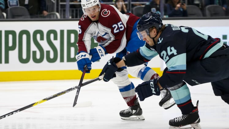 Apr 20, 2022; Seattle, Washington, USA; Colorado Avalanche right wing Logan O'Connor (25) passes the puck against Seattle Kraken defenseman Jamie Oleksiak (24) during the first period at Climate Pledge Arena. Mandatory Credit: Joe Nicholson-USA TODAY Sports