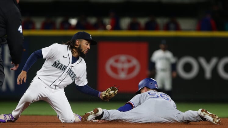 Apr 20, 2022; Seattle, Washington, USA; Seattle Mariners shortstop J.P. Crawford (3) catches Texas Rangers right fielder Kole Calhoun (56) stealing second base for an out during the fifth inning at T-Mobile Park. Mandatory Credit: Lindsey Wasson-USA TODAY Sports