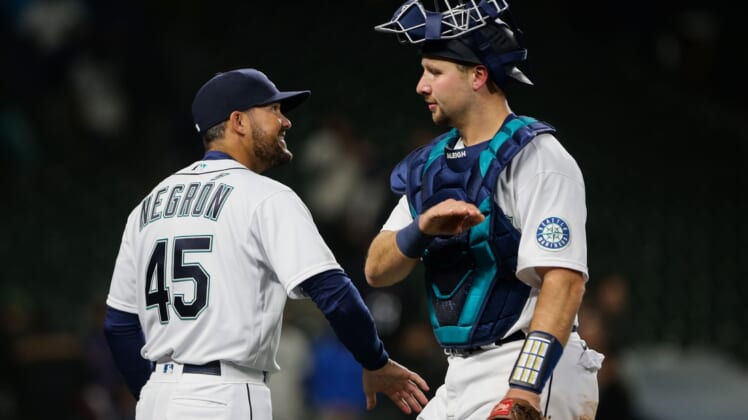 Apr 20, 2022; Seattle, Washington, USA;  Seattle Mariners first base coach and current acting manager Kristopher Negron (45) celebrates the win against the Texas Rangers with catcher Cal Raleigh (29) at T-Mobile Park. Seattle Mariners manager Scott Servais tested positive for COVID-19 earlier in the day. Mandatory Credit: Lindsey Wasson-USA TODAY Sports
