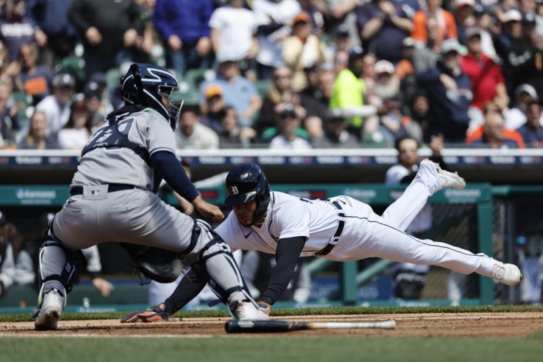 Apr 21, 2022; Detroit, Michigan, USA;  Detroit Tigers right fielder Victor Reyes (22) dives in safe at home ahead of the tag by New York Yankees catcher Jose Trevino (39) in the third inning at Comerica Park. Mandatory Credit: Rick Osentoski-USA TODAY Sports