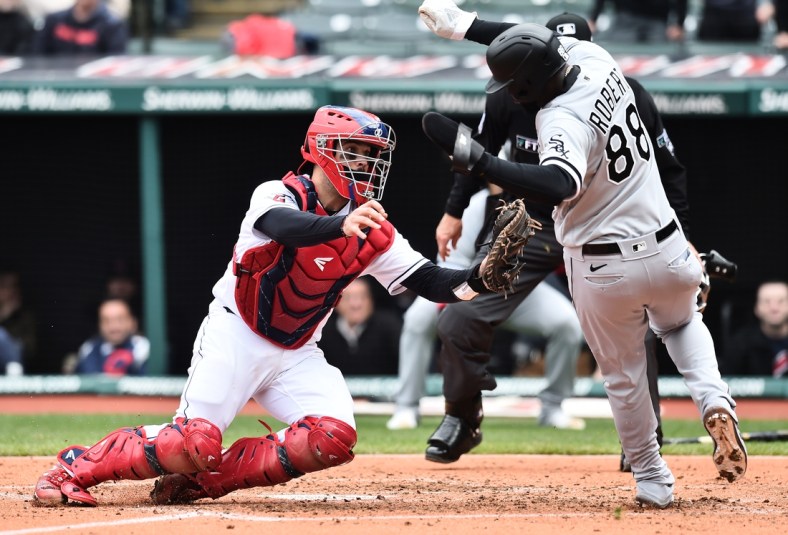 Apr 21, 2022; Cleveland, Ohio, USA; Cleveland Guardians catcher Austin Hedges (17) tags out Chicago White Sox center fielder Luis Robert (88) during the fourth inning at Progressive Field. Mandatory Credit: Ken Blaze-USA TODAY Sports