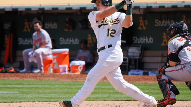 Apr 21, 2022; Oakland, California, USA; Oakland Athletics catcher Sean Murphy (12) hits an RBI double against the Baltimore Orioles during the seventh inning at RingCentral Coliseum. Mandatory Credit: Kelley L Cox-USA TODAY Sports