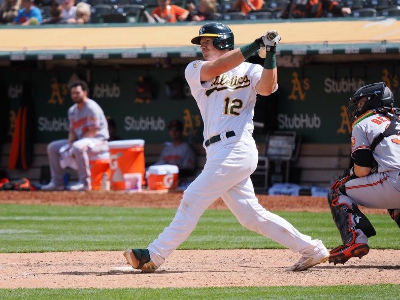 Apr 21, 2022; Oakland, California, USA; Oakland Athletics catcher Sean Murphy (12) hits an RBI double against the Baltimore Orioles during the seventh inning at RingCentral Coliseum. Mandatory Credit: Kelley L Cox-USA TODAY Sports