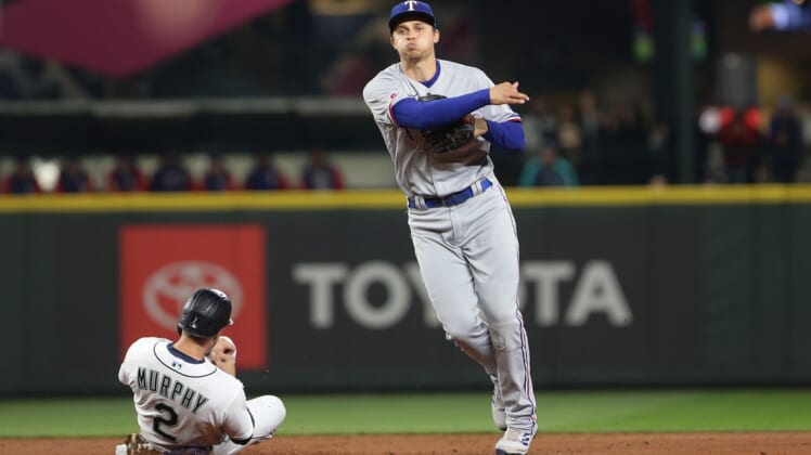 Apr 21, 2022; Seattle, Washington, USA;  Texas Rangers shortstop Corey Seager (5) throws to first after making the out on Seattle Mariners catcher Tom Murphy (2) at second during the first inning at T-Mobile Park. Mandatory Credit: Lindsey Wasson-USA TODAY Sports