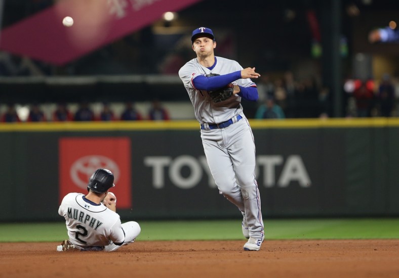 Apr 21, 2022; Seattle, Washington, USA;  Texas Rangers shortstop Corey Seager (5) throws to first after making the out on Seattle Mariners catcher Tom Murphy (2) at second during the first inning at T-Mobile Park. Mandatory Credit: Lindsey Wasson-USA TODAY Sports