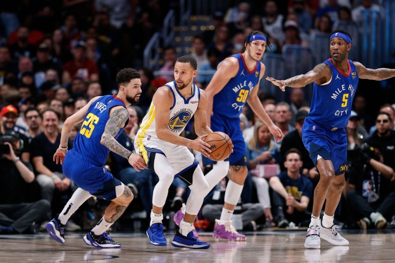 Apr 21, 2022; Denver, Colorado, USA; Golden State Warriors guard Stephen Curry (30) controls the ball as Denver Nuggets guard Austin Rivers (25) and forward Aaron Gordon (50) and forward Will Barton (5) defend in the first quarter during game three of the first round for the 2022 NBA playoffs at Ball Arena. Mandatory Credit: Isaiah J. Downing-USA TODAY Sports