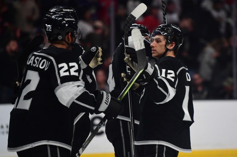 Apr 21, 2022; Los Angeles, California, USA; Los Angeles Kings center Trevor Moore (12) and center Andreas Athanasiou (22) celebrate the victory against the Chicago Blackhawks at Crypto.com Arena. Mandatory Credit: Gary A. Vasquez-USA TODAY Sports
