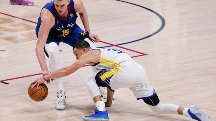 Apr 21, 2022; Denver, Colorado, USA; Golden State Warriors guard Stephen Curry (30) and Denver Nuggets center Nikola Jokic (15) battle for a loose ball in the fourth quarter during game three of the first round of the 2022 NBA playoffs at Ball Arena. Mandatory Credit: Isaiah J. Downing-USA TODAY Sports