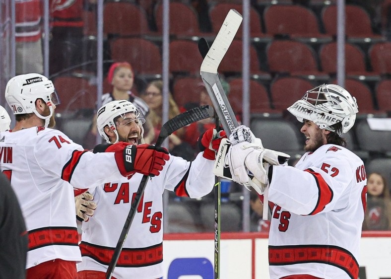 Apr 23, 2022; Newark, New Jersey, USA; Carolina Hurricanes goaltender Pyotr Kochetkov (52) celebrates with defenseman Jaccob Slavin (74) and center Vincent Trocheck (16) after an overtime victory against the New Jersey Devils at Prudential Center. Mandatory Credit: Vincent Carchietta-USA TODAY Sports