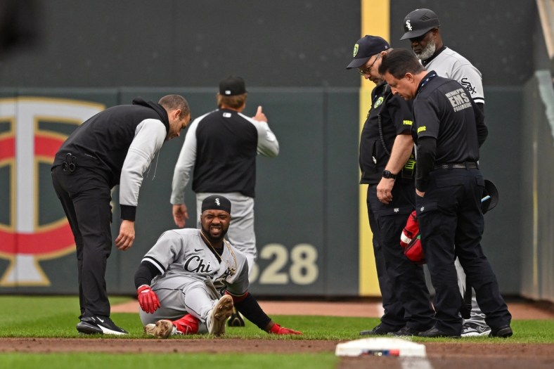 Apr 23, 2022; Minneapolis, Minnesota, USA;  Members of the medical staff check on Chicago White Sox left fielder Eloy Jimenez (74) after he is injured running to first on a ground ball against the Minnesota Twins during the second inning at Target Field. Mandatory Credit: Nick Wosika-USA TODAY Sports