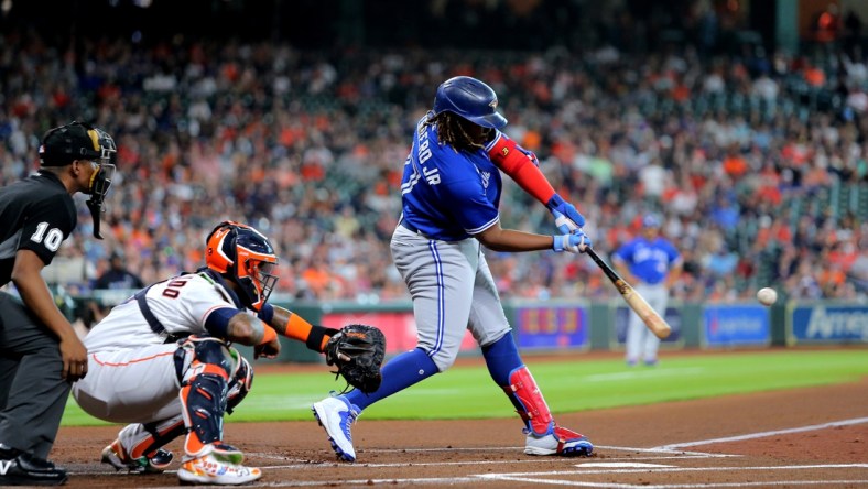 Apr 23, 2022; Houston, Texas, USA; Toronto Blue Jays first baseman Vladimir Guerrero Jr. (27) hits a single to left field against the Houston Astros during the first inning at Minute Maid Park. Mandatory Credit: Erik Williams-USA TODAY Sports