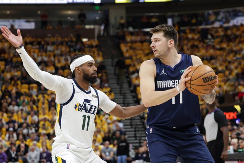 Apr 23, 2022; Salt Lake City, Utah, USA; Dallas Mavericks guard Luka Doncic (77) keeps the ball away from Utah Jazz guard Mike Conley (11) during the first quarter during game four of the first round for the 2022 NBA playoffs at Vivint Arena. Mandatory Credit: Chris Nicoll-USA TODAY Sports