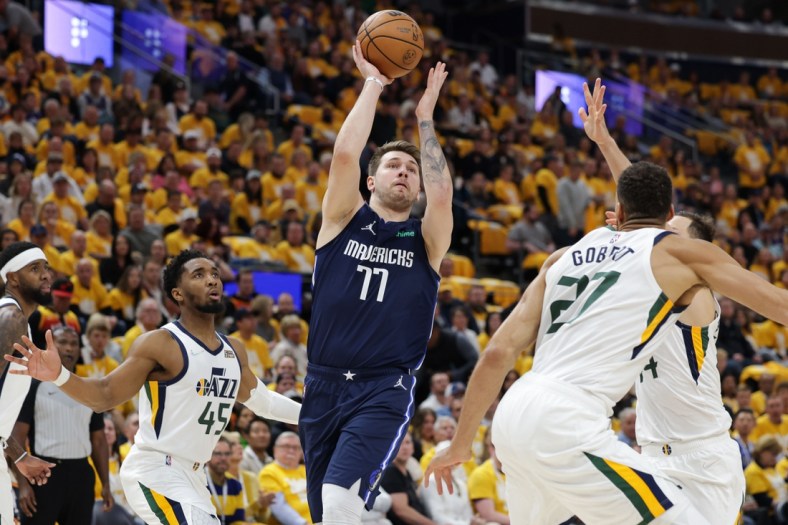 Apr 23, 2022; Salt Lake City, Utah, USA; Dallas Mavericks guard Luka Doncic (77) shoots the ball between Utah Jazz guard Donovan Mitchell (45) and center Rudy Gobert (27) during the first quarter during game four of the first round for the 2022 NBA playoffs at Vivint Arena. Mandatory Credit: Chris Nicoll-USA TODAY Sports