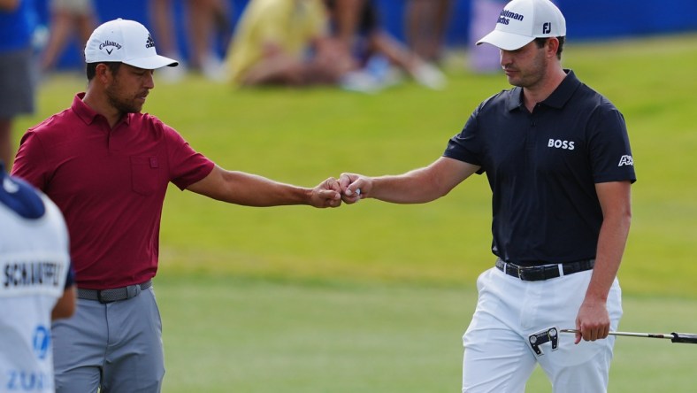 Apr 23, 2022; Avondale, Louisiana, USA; Patrick Cantlay and Xander Schauffele fist bump on the 17th hole during the third round of the Zurich Classic of New Orleans golf tournament. Mandatory Credit: Andrew Wevers-USA TODAY Sports