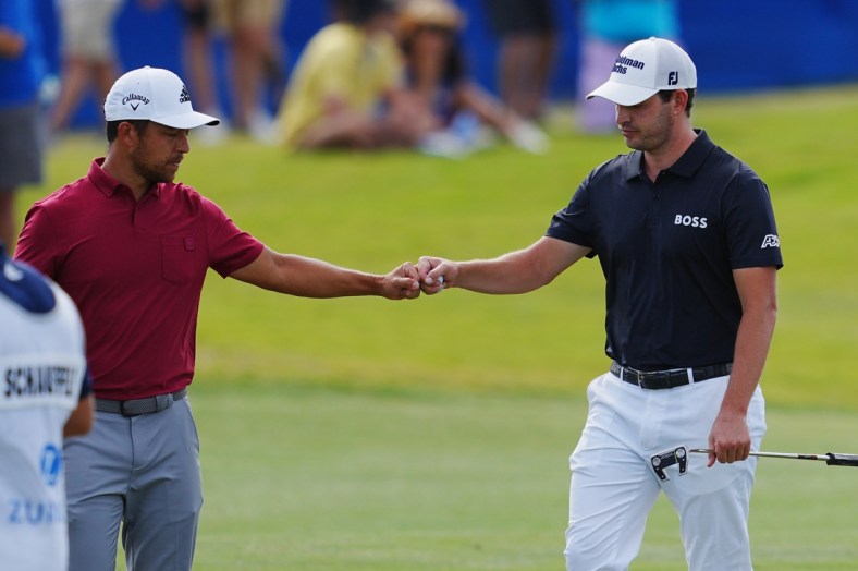 Apr 23, 2022; Avondale, Louisiana, USA; Patrick Cantlay and Xander Schauffele fist bump on the 17th hole during the third round of the Zurich Classic of New Orleans golf tournament. Mandatory Credit: Andrew Wevers-USA TODAY Sports