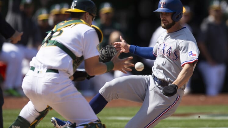 Apr 23, 2022; Oakland, California, USA; Texas Rangers designated hitter Eli White (41) slides safely home ahead of the tag by Oakland Athletics catcher Sean Murphy (12) on a single by Brad Miller during the eighth inning at RingCentral Coliseum. Mandatory Credit: D. Ross Cameron-USA TODAY Sports