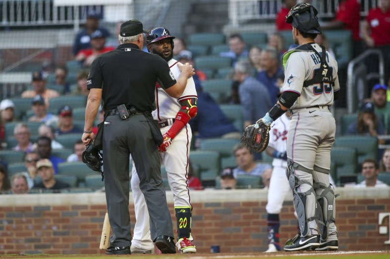 Apr 23, 2022; Atlanta, Georgia, USA; Atlanta Braves left fielder Marcell Ozuna (20) is held back by umpire Ted Barrett (65) while talking to Miami Marlins catcher Payton Henry (59) after being hit by a pitch in the first inning at Truist Park. Mandatory Credit: Brett Davis-USA TODAY Sports