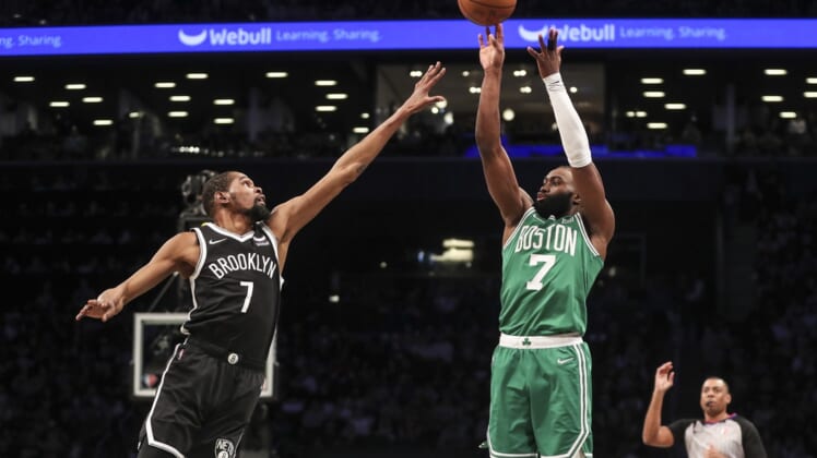 Apr 23, 2022; Brooklyn, New York, USA;  Boston Celtics guard Jaylen Brown (7) takes a three point shot over Brooklyn Nets forward Kevin Durant (7) in the first quarter at Barclays Center. Mandatory Credit: Wendell Cruz-USA TODAY Sports