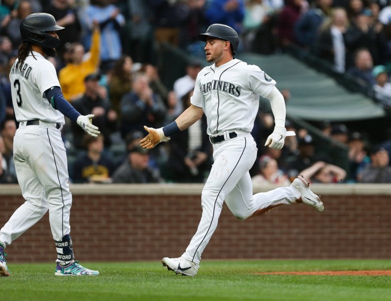 Apr 23, 2022; Seattle, Washington, USA;  Seattle Mariners right fielder Jarred Kelenic (10) greets shortstop J.P. Crawford (3) after scoring during the second inning against the Kansas City Royals at T-Mobile Park. Mandatory Credit: Lindsey Wasson-USA TODAY Sports