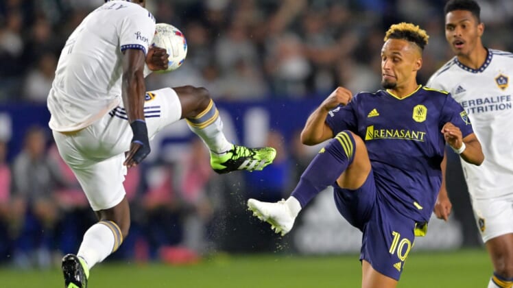 Apr 23, 2022; Carson, California, USA;  Los Angeles Galaxy defender Sega Coulibaly (4) and Nashville SC midfielder Hany Mukhtar (10) battle for the ball in the first half at Dignity Health Sports Park. Mandatory Credit: Jayne Kamin-Oncea-USA TODAY Sports