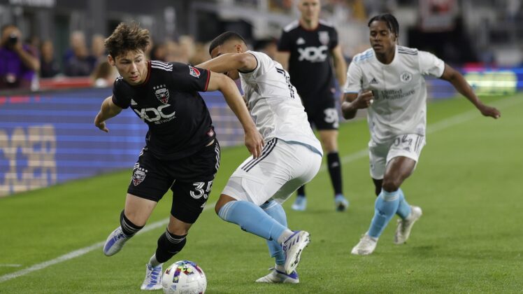 Apr 23, 2022; Washington, District of Columbia, USA;  D.C. United midfielder Theodore Ku-DiPietro (35) dribbles the ball as New England Revolution midfielder Damian Rivera (72) defends in the second half at Audi Field. Mandatory Credit: Geoff Burke-USA TODAY Sports
