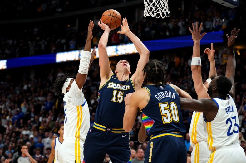 Apr 24, 2022; Denver, Colorado, USA; Denver Nuggets center Nikola Jokic (15) shoots past Golden State Warriors center Kevon Looney (5) in the first quarter of the first round for the 2022 NBA playoffs at Ball Arena. Mandatory Credit: Ron Chenoy-USA TODAY Sports