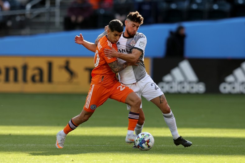 Apr 24, 2022; New York, NY, New York, NY, USA; New York City FC midfielder Santiago Rodriguez (20) and Toronto FC midfielder Jonathan Osorio (21) fight for the ball during the first half at Citi Field. Mandatory Credit: Brad Penner-USA TODAY Sports