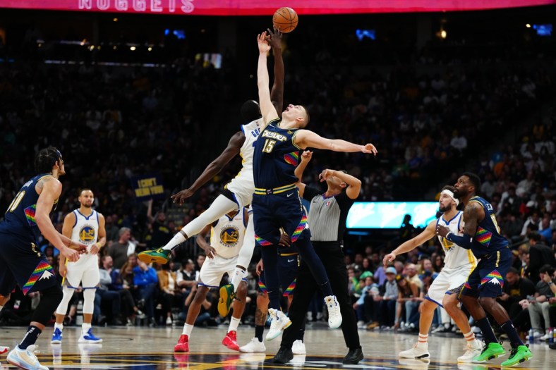 Apr 24, 2022; Denver, Colorado, USA; Denver Nuggets center Nikola Jokic (15) and Golden State Warriors forward Draymond Green (23) reach for a jump ball in the second half of the first round for the 2022 NBA playoffs at Ball Arena. Mandatory Credit: Ron Chenoy-USA TODAY Sports