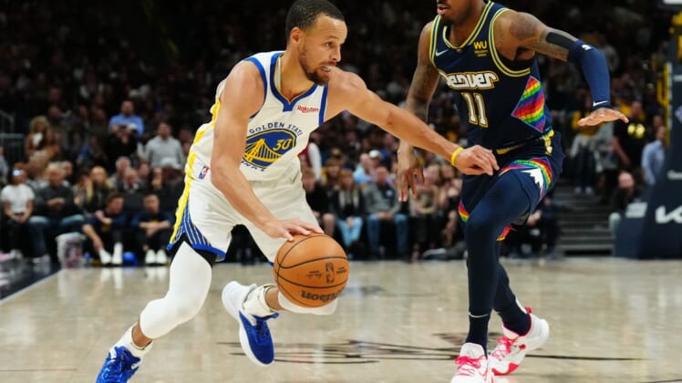 Apr 24, 2022; Denver, Colorado, USA; Golden State Warriors guard Stephen Curry (30) drives at Denver Nuggets guard Monte Morris (11) in the second half of the first round for the 2022 NBA playoffs at Ball Arena. Mandatory Credit: Ron Chenoy-USA TODAY Sports