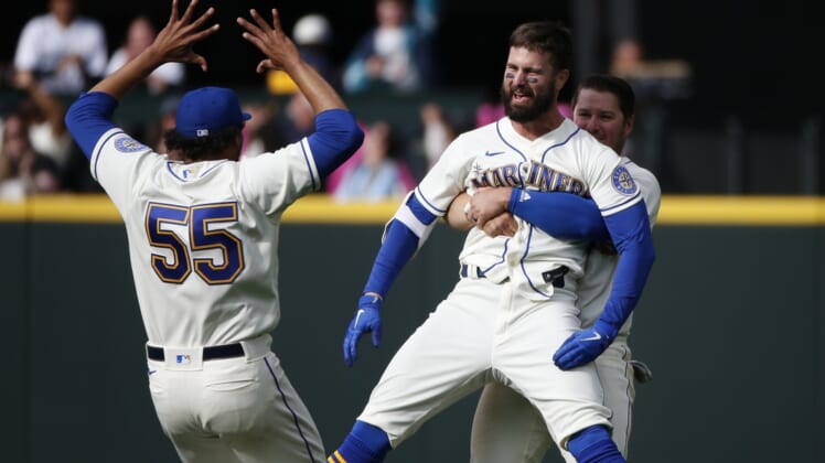 Apr 24, 2022; Seattle, Washington, USA; Seattle Mariners right fielder Jesse Winker (27) is hugged by third baseman Ty France (23, right) after hitting a walk-off RBI-single against the Kansas City Royals during the twelfth inning at T-Mobile Park. Seattle defeated Kansas City, 5-4. Mandatory Credit: Joe Nicholson-USA TODAY Sports