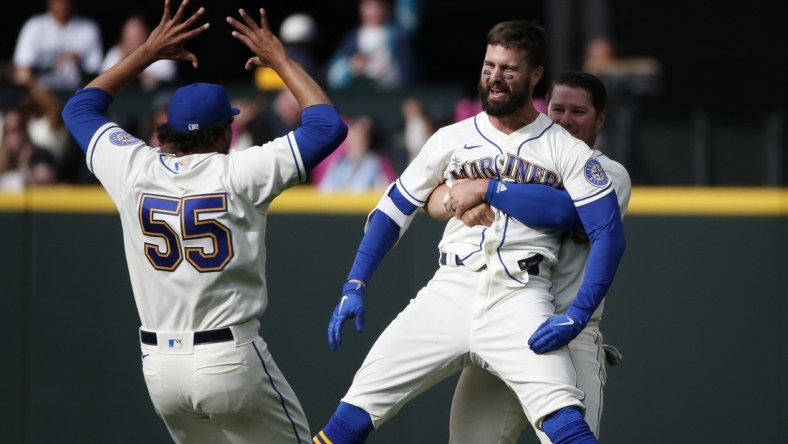 Apr 24, 2022; Seattle, Washington, USA; Seattle Mariners right fielder Jesse Winker (27) is hugged by third baseman Ty France (23, right) after hitting a walk-off RBI-single against the Kansas City Royals during the twelfth inning at T-Mobile Park. Seattle defeated Kansas City, 5-4. Mandatory Credit: Joe Nicholson-USA TODAY Sports