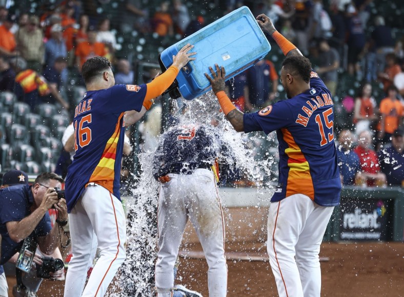 Apr 24, 2022; Houston, Texas, USA; Houston Astros second baseman Aledmys Diaz (16) and catcher Martin Maldonado (15) pour an ice bucket on shortstop Jeremy Pena (3) after Pena hit a walk-off home run during the tenth inning against the Toronto Blue Jays at Minute Maid Park. Mandatory Credit: Troy Taormina-USA TODAY Sports