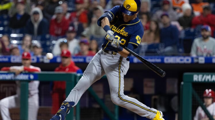 Apr 24, 2022; Philadelphia, Pennsylvania, USA; Milwaukee Brewers left fielder Christian Yelich (22) hits an RBI sacrifice fly during the ninth inning against the Philadelphia Phillies at Citizens Bank Park. Mandatory Credit: Bill Streicher-USA TODAY Sports