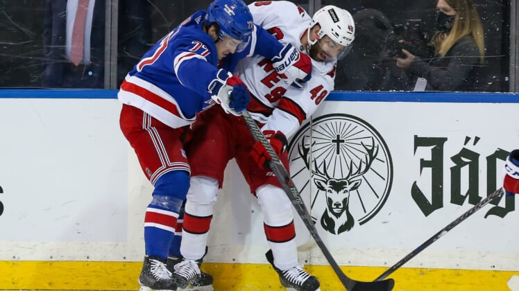 Apr 26, 2022; New York, New York, USA; Carolina Hurricanes left wing Jordan Martinook (48) and New York Rangers center Frank Vatrano (77) battle for the puck along the boards during the first period at Madison Square Garden. Mandatory Credit: Tom Horak-USA TODAY Sports