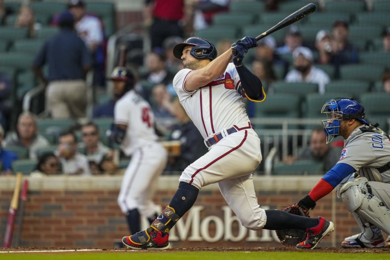 Apr 26, 2022; Cumberland, Georgia, USA; Atlanta Braves center fielder Adam Duvall (14) drives in a run with a sacrifice fly ball against the Chicago Cubs during the second inning at Truist Park. Mandatory Credit: Dale Zanine-USA TODAY Sports