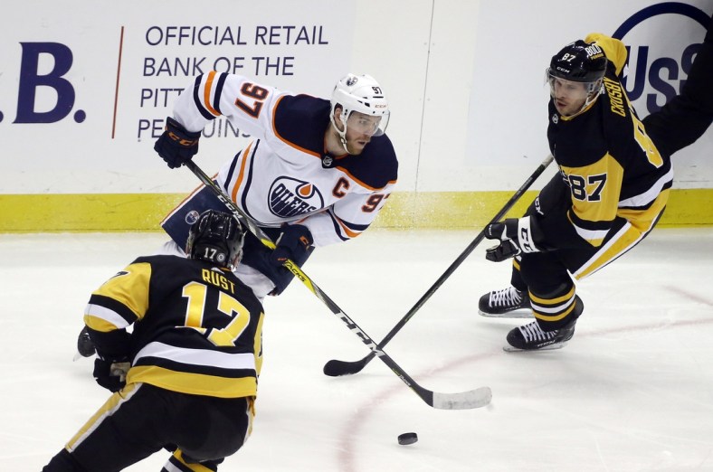 Apr 26, 2022; Pittsburgh, Pennsylvania, USA; Edmonton Oilers center Connor McDavid (97) handles the puck against Pittsburgh Penguins right wing Bryan Rust (17) and center Sidney Crosby (87) during the second period at PPG Paints Arena. Mandatory Credit: Charles LeClaire-USA TODAY Sports