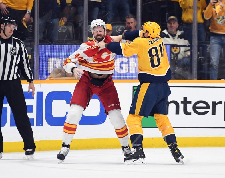 Apr 26, 2022; Nashville, Tennessee, USA; Calgary Flames defenseman Erik Gudbranson (44) and Nashville Predators left wing Tanner Jeannot (84) exchange hits during a fight during the first period at Bridgestone Arena. Mandatory Credit: Christopher Hanewinckel-USA TODAY Sports