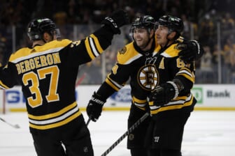 Apr 26, 2022; Boston, Massachusetts, USA; Boston Bruins left wing Brad Marchand (63) is congratulated by left wing Jake DeBrusk (74) and center Patrice Bergeron (37) after scoring against the Florida Panthers during the third period at TD Garden. Mandatory Credit: Winslow Townson-USA TODAY Sports