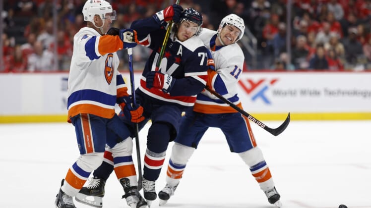 Apr 26, 2022; Washington, District of Columbia, USA; Washington Capitals right wing T.J. Oshie (77) battle for the puck with New York Islanders defenseman Andy Greene (4)  and Islanders left wing Zach Parise (11) in the third period at Capital One Arena. Mandatory Credit: Geoff Burke-USA TODAY Sports