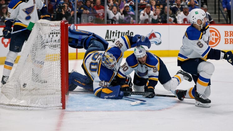 Apr 26, 2022; Denver, Colorado, USA; St. Louis Blues goaltender Jordan Binnington (50) dives for the puck as it hits the back of the net as center Ryan O'Reilly (90) and defenseman Marco Scandella (6) defend as Colorado Avalanche center Alex Newhook (18) lies on the ice in the second period at Ball Arena. Mandatory Credit: Isaiah J. Downing-USA TODAY Sports