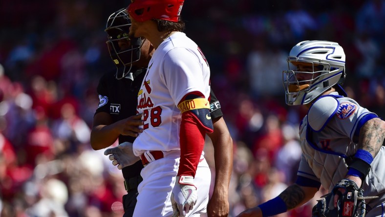 Apr 27, 2022; St. Louis, Missouri, USA;  St. Louis Cardinals designated hitter Nolan Arenado (28) reacts as he is held back by umpire Jeremie Rehak (35) after a high and tight pitch from New York Mets relief pitcher Yoan Lopez (not pictured) during the eighth inning at Busch Stadium. Mandatory Credit: Jeff Curry-USA TODAY Sports