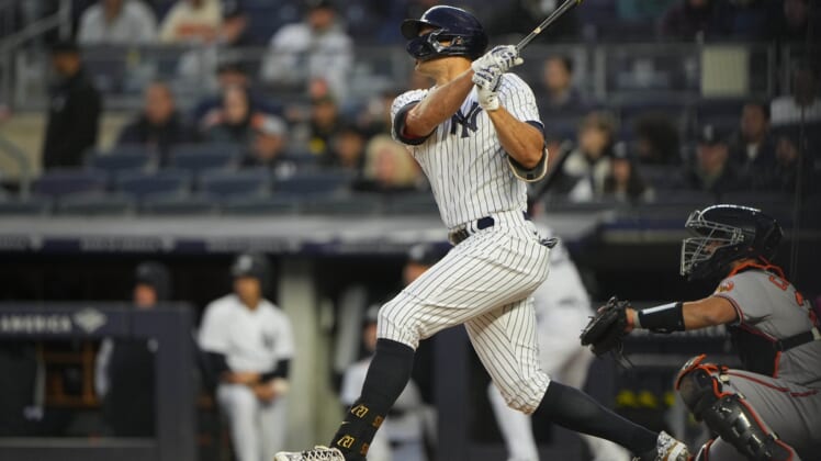 Apr 27, 2022; Bronx, New York, USA; New York Yankees right fielder Giancarlo Stanton (27) hits a two-run home run against the Baltimore Orioles during the first inning at Yankee Stadium. Mandatory Credit: Gregory Fisher-USA TODAY Sports